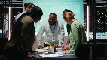 onderneming adviserend bord vergadering laat Bij nacht naar beoordelen risico's en uitwisseling feedback, samenwerken Aan project inzichten gesteund door bedrijf Intel en statistieken diagrammen. werk team. camera a. video