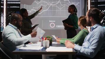 olika företag konsulter granskning mål och förslag för en projekt dagordning, granskning data insikter på en utsprång styrelse med aktieägare efter timmar i en genomgång session. kamera a. video