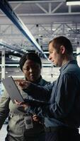 Vertical Data center coworkers doing brainstorming, monitoring deep learning processes, reviewing operational metrics. Colleagues working together to review neural networks reports during inspection, camera A video