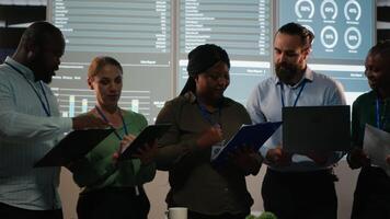 Portrait of multiethnic business team collaborating late at night, assembling in a dark office after hours and working on enterprise development. Diversity within the advisory board group. Camera B. video