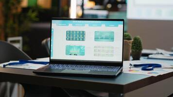 Laptop in a dark office multinational company with business analytics, charts and forecasting dashboard awaiting a strategy session to align corporate project development with goals. video