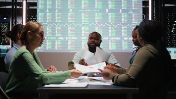 olika yrkesverksamma grupp utvärdera filer och prestanda indikatorer, använder sig av framskrivningar och diagram till justera de företag mål med investerare förväntningar för företag framsteg. kamera a. video