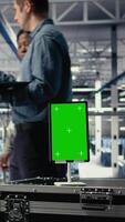 Vertical Green screen tablet in server room in front of admins optimizing deep learning systems handling tasks. Mockup device used by data center workers adjusting AI model parameters, camera A video
