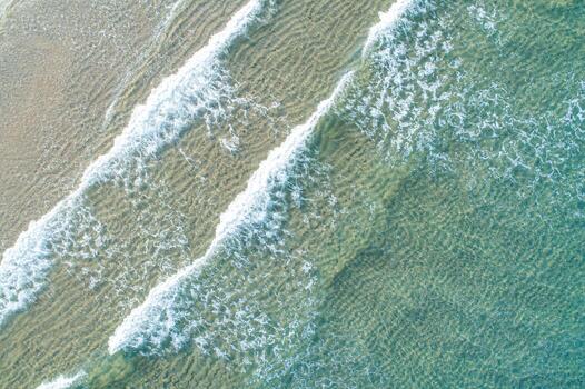 Top down aerial view of multiple waves on a shallow beach. A Rhythmic Pattern photo