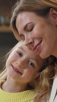 Happy family at kitchen portrait Caucasian preschool cute affectionate adopted little girl child daughter schoolgirl hugging cuddle care mother with closed eyes cuddling mum kid enjoy tender at home video