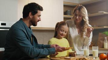 Happy smile Caucasian family together at kitchen at home parents with child kid daughter preparing cook breakfast eating chocolate sandwich mother father little girl organic food supermarket delivery video