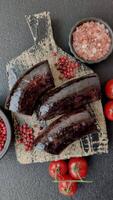 negro sangre salchicha con especias y hierbas A la parrilla en un negro hormigón antecedentes video