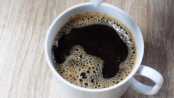 svart kaffe, socker kub droppar in i varm svart kaffe, orsakar en stänk och krusningar. närbild skott med rik kaffe textur, idealisk för dryck, mat, och livsstil innehåll video