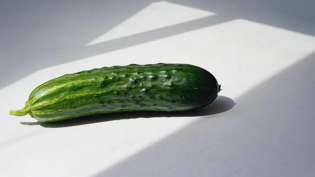 a cucumber is sitting on a white surface photo