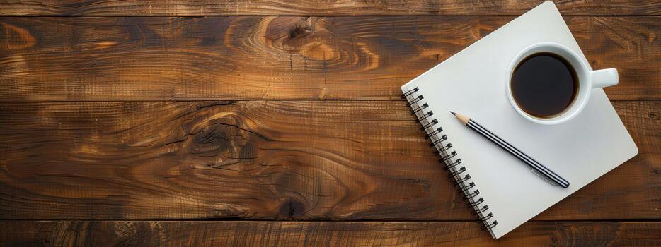 A wooden table with a white notebook and a coffee cup on it. The notebook is open to a page with a pencil on it. The scene suggests a moment of relaxation or contemplation photo