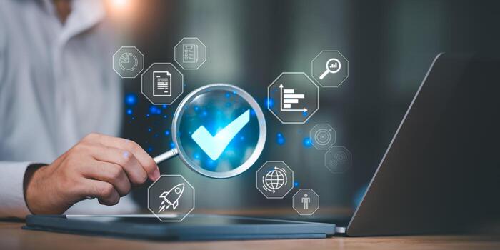 Businessman using magnifying glass with digital check mark and data icons, representing quality assurance, business analysis, performance review, and strategic decision-making. photo
