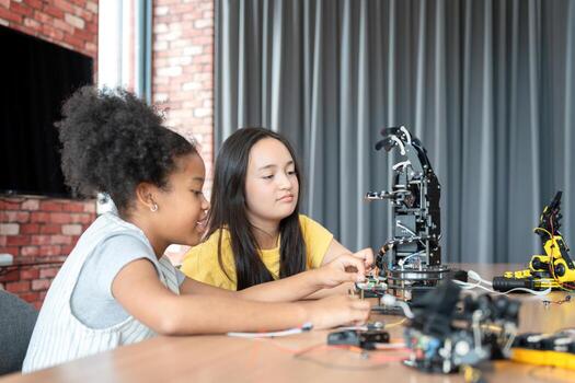 Young Girl and Friend Engaged in Robotics and STEM Learning, Diverse Kids Building a Robot Arm in a Science Workshop, Two Girls Exploring Technology and Innovation photo