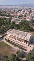 antenn se av tempel av hepestest i aten, grekland. gammal grekisk arkitektur omgiven förbi grönska med panorama- se av stad byggnader och bergen i de bakgrund. video