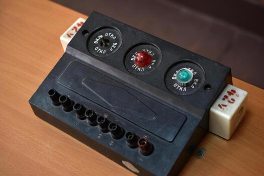 Outdated machine control interface with mechanical switches and glowing indicator lights. photo