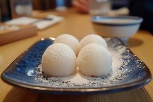 Delicious Mochi Dessert Served on a Blue Plate with Powdered Sugar. photo