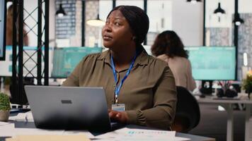 svart företags- chef recensioner planera dokument och justerar strategi, ser till nyckel data in i henne dator. tilldelning Resurser för projekt utveckling och komplettering. kamera b. video