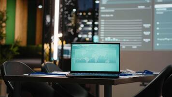stänga upp av bärbar dator i tömma företags- kontor efter timmar, projiceras diagram och analys redo för projekt genomgångar och strategisk möten inom en Framgång fokuserade organisation. video