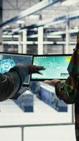 Vertical Close up of military data center colleagues looking at radar software to watch for enemy threats. Teamworking army staff members in data center scan suspicious activity to detect dangers, camera A video