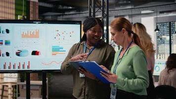 multietnico donne d'affari unendo per revisione finanza rapporti e analitica nel un' dinamico opera ambiente, mescolanza prestazione indicatori con visionario strategia e forte squadra sinergia. telecamera un. video