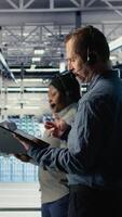 vertical datos centrar técnico utilizando ai en tableta a ayuda clientes resolver sitio web hospedaje problemas. servidor granja tecnología apoyo profesional Ayudar los usuarios mantener su en línea servicios corriendo suavemente, cámara un video
