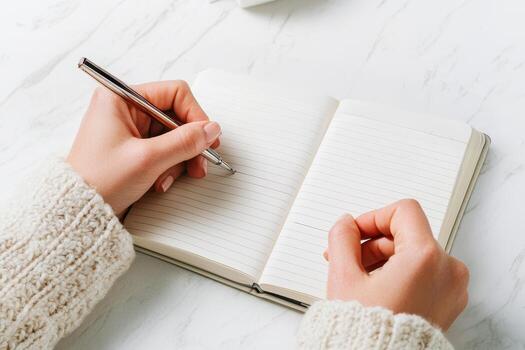 Writing journal with hands in knitted sweater writing on paper photo