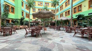 en gård med tabeller och stolar i främre av en byggnad video