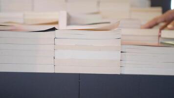 Exploring a stack of books at a local market video