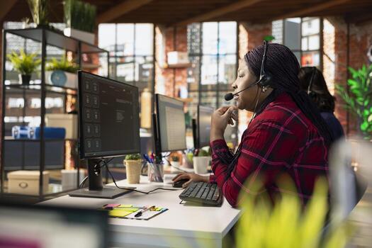 Call center agent at office desk using AI to enhance customer interaction and resolve inquiries efficiently. African american customer service employee using AI communication technologies photo
