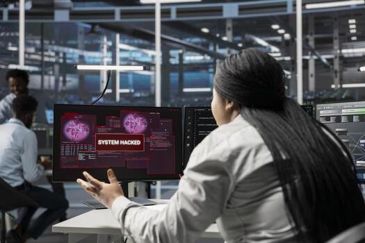 IT expert using PC in server farm to protect hardware from hacker attack stealing sensitive information. Data center employee seeing security breach alert on monitor, struggling to protect equipment photo