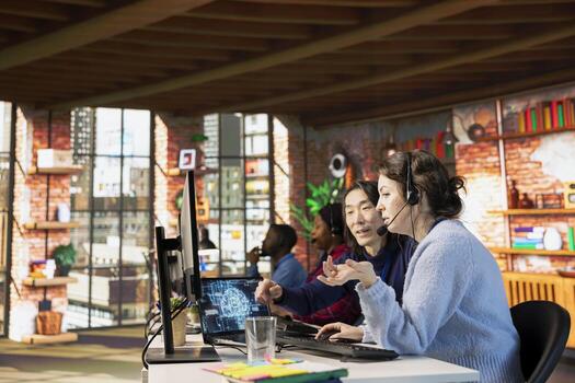 Experienced call center manager guiding intern on how to use AI chatbot in office. Asian customer support workplace onboarding specialist teaching new worker to use artificial intelligence assistant photo