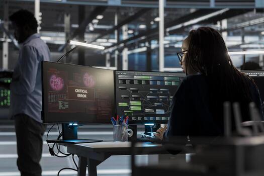 Woman in server room finding glitches while overseeing AI systems. Data center IT professional seeing critical error warning while trying to visualize artificial intelligence neural networks photo