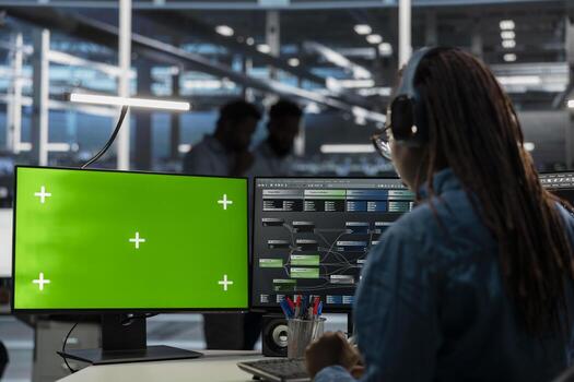 System administrator in server farm using isolated screen PC to repair equipment storing datasets. IT expert using chroma key computer to do debugging on rigs doing computational operations photo