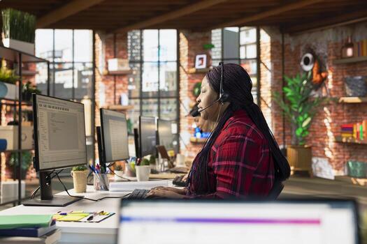 Call center agent helping customer, debugging code issues in office at PC desk. Customer support worker assisting users with troubleshooting and resolving programming errors photo