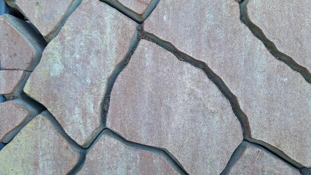 Close-up of weathered stone surface with cracks and textured patterns photo