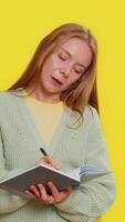 nachdenklich Journalist kaukasisch mittleren Alters Frau 40 Jahre alt Herstellung Anmerkungen, Schreiben Nieder Gedanken mit Stift in Notizblock Notizbuch Tagebuch, zu tun Liste, gut Idee. Erwachsene Mädchen isoliert auf Gelb Hintergrund video
