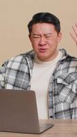 scontento asiatico Cinese uomo utilizzando il computer portatile taccuino digitando Lavorando, perde diventare sorpreso improvviso lotteria risultati cattivo notizia fortuna perdita gioco fallire computer virus seduta a tavolo su beige sfondo. video