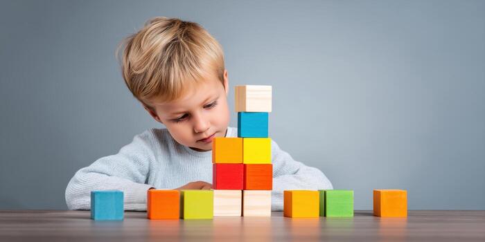 young boy concentrating on block tower. photo