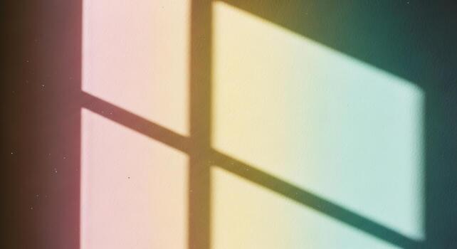 Soft rainbow colored light patterns cast by a window onto a dark background creating a gentle abstract design photo