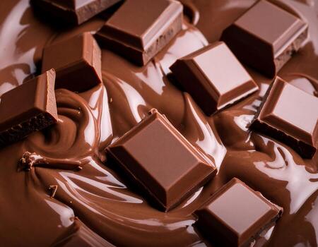 Melted liquid chocolate texture background, some bitter chocolate parts falling in this liquid photo