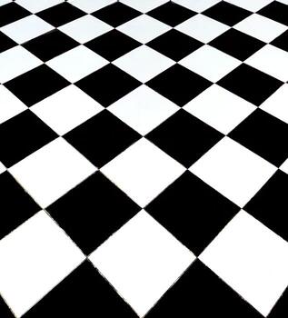 A low-angle shot captures the dramatic perspective of a glossy black and white checkerboard floor, where the diagonal grid recedes into the distance. The high contrast and repetitive pattern create a photo