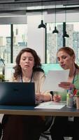 vertikal multietnisk mål orienterad team av kvinnor demonstrerar de kraft av ledarskap, samarbetande på styrelserum planera med data analys och rapporterar. modern arbete miljö. kamera a. video