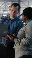 Vertical Server room coworkers scan infrastructure for security issues using laptop. Data center system administrators using notebook to organize file backups and plan recovery steps, camera B video
