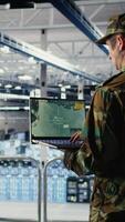 Vertical Military data center specialist using radar software on laptop to watch for enemy threats. Army soldier in data center scans suspicious activity to detect dangers using notebook, camera A video