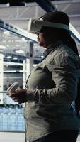 verticale Software sviluppatore nel server camera indossare vr occhiali ottimizzazione in profondità apprendimento sistemi maneggio compiti. africano americano donna nel dati centro regola ai modello parametri utilizzando virtuale realtà, telecamera un' video
