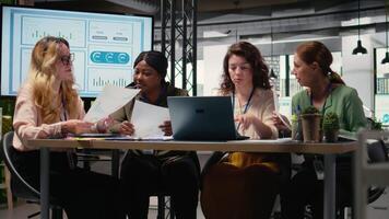 grupp av affärskvinna engagerande i samarbete under genomgång session, analyserar data och skrivning rapporter medan fattande en attityd av tillväxt. mål orienterad möte. kamera a. video