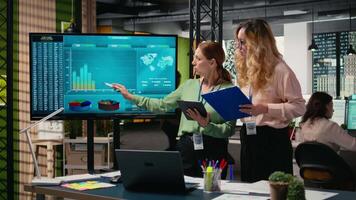 Goals oriented businesswomen representing strategic collaboration in the office, using tablet and data reports to build strong goals alignment and inspire achievement across company. Camera A. video