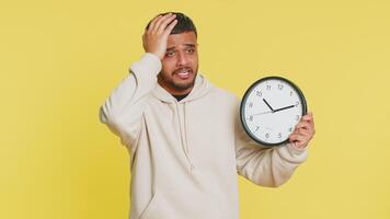 indiano giovane uomo con ansia controllo tempo su orologio, in esecuzione in ritardo per opera, essere nel ritardo, Scadenza. arabo tipo guardare a ora, minuti, preoccupante per essere puntuale isolato su studio giallo sfondo video