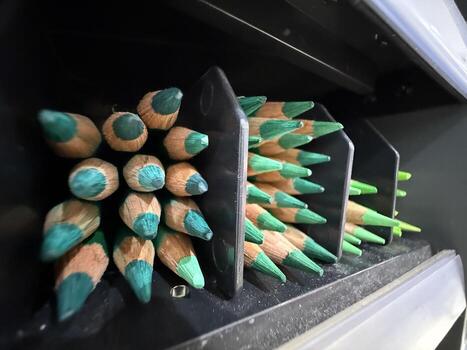 Green pencils stacked in holder creating geometric pattern suitable as background or design element photo