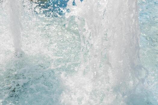 In a vibrant park on a sunny afternoon, water streams and droplets burst from the fountain, creating a playful and refreshing atmosphere for visitors enjoying the day photo