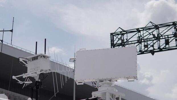 Advanced radar system showcased at a testing facility, equipped with antennas and monitoring capabilities, operating on a cloudy day with dramatic skies. photo